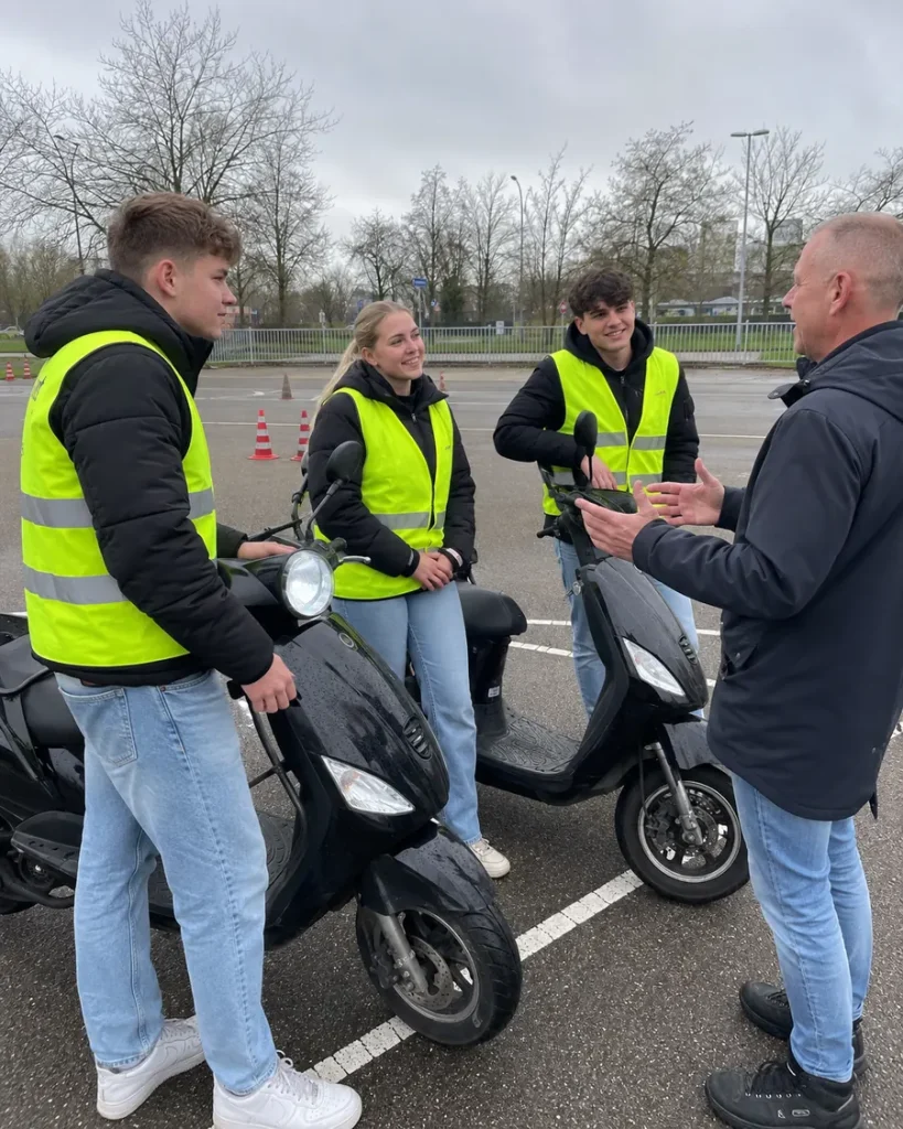 Leerlingen rijden op lesscooters over het oefenterrein